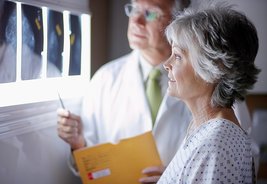 Bildgebende Verfahren gehören zu den Säulen der modernen Medizintechnik. Bild zeigt: Arzt mit Patientin vor Röntgenbildern